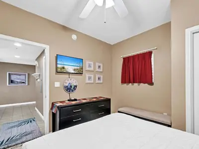 a bedroom with a bed and a dresser with a mirror at Sterling Reef 1203 in Panama City Beach