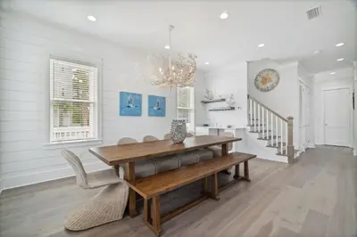 a dining room with a wooden table and a chandelier at 30A Beach House - Wonderland at Treetop by Panhandle Getaways in Rosemary Beach