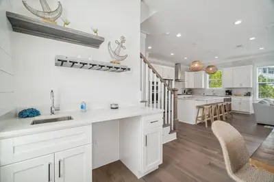 a kitchen with white cabinets and a dining room at 30A Beach House - Wonderland at Treetop by Panhandle Getaways in Rosemary Beach