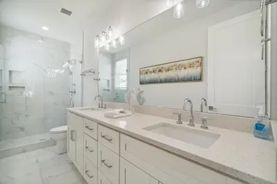 a white bathroom with a sink and a toilet at 30A Beach House - Wonderland at Treetop by Panhandle Getaways in Rosemary Beach