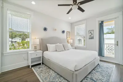a white bedroom with a bed and two windows at 30A Beach House - Wonderland at Treetop by Panhandle Getaways in Rosemary Beach