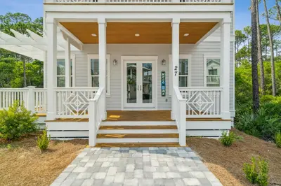 a white house with a front porch with white columns at 30A Beach House - Wonderland at Treetop by Panhandle Getaways in Rosemary Beach