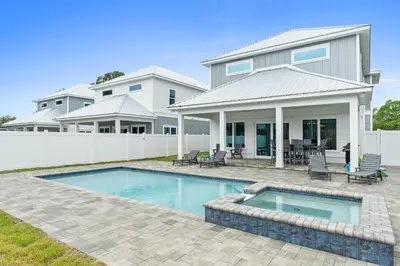 a house with a swimming pool in front of a house at Pet Friendly Beach House - Totally Beachin by Panhandle Getaways in Panama City Beach