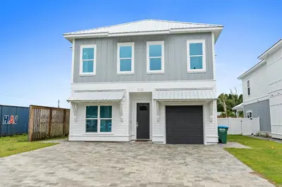 a large white house with a garage at Pet Friendly Beach House - Totally Beachin by Panhandle Getaways in Panama City Beach