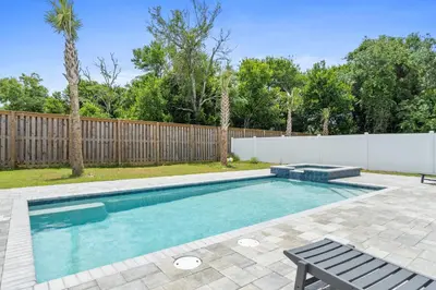 a swimming pool with a bench and a fence at Pet Friendly Beach House - Totally Beachin by Panhandle Getaways in Panama City Beach