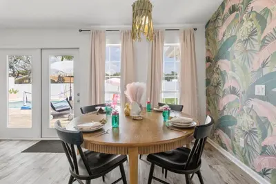 a dining room with a wooden table and chairs at Steps to the beach & close to 30A! Private pool with sundeck & putt putt golf! in Panama City Beach