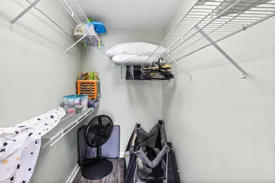 a bedroom with a bed and two bikes on a shelf at Steps to the beach & close to 30A! Private pool with sundeck & putt putt golf! in Panama City Beach