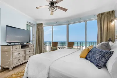 a bedroom with a large bed and a flat screen tv at Boardwalk 209 in Panama City Beach