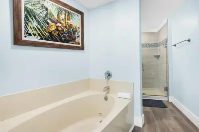 a bathroom with a tub and a painting on the wall at Boardwalk 209 in Panama City Beach