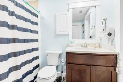 a bathroom with a toilet and a sink and a mirror at Boardwalk 209 in Panama City Beach