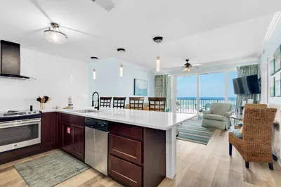 a kitchen and living room with a view of the ocean at Boardwalk 209 in Panama City Beach