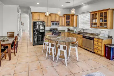 a kitchen with wooden cabinets and a table and chairs at 136 La Valencia Cir - At Peace in Panama City Beach