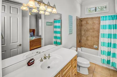 a bathroom with a sink and a tub and a toilet at 136 La Valencia Cir - At Peace in Panama City Beach