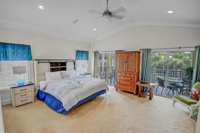 a bedroom with a bed and a balcony at 136 La Valencia Cir - At Peace in Panama City Beach