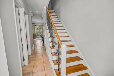 a staircase in a house with white walls and wooden floors at 136 La Valencia Cir - At Peace in Panama City Beach