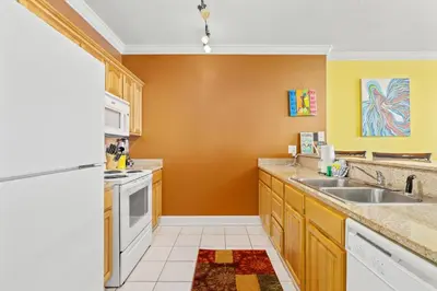 a kitchen with a sink and a refrigerator at Ocean Reef 1106 - Lazy Daze in Panama City Beach