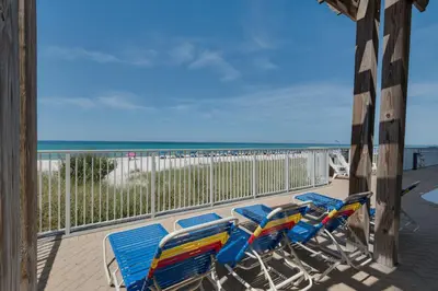 a group of chairs and tables on a balcony with the beach at Ocean Reef 1106 - Lazy Daze in Panama City Beach