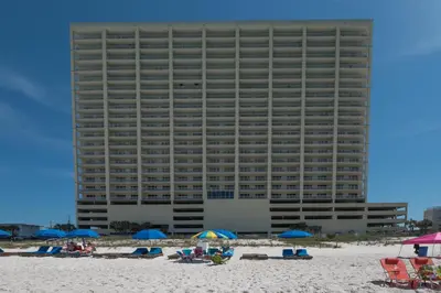 a large building on the beach with chairs and umbrellas at Ocean Reef 1106 - Lazy Daze in Panama City Beach