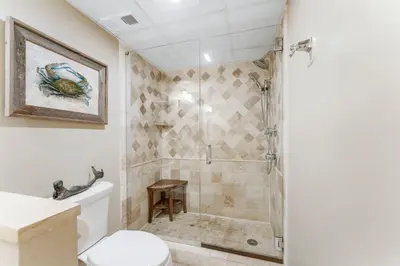a bathroom with a shower and a toilet at Stunning 2/2 Designer Condo w Coastal Appeal Right on the Gulf! in Panama City Beach
