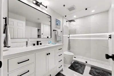 a white bathroom with a sink and a shower at Luxury Gulf-View 3BD Condo! Free Beach Chairs! by Dolce Vita Getaways PCB in Panama City Beach