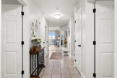a hallway with white doors and a tile floor at Luxury Gulf-View 3BD Condo! Free Beach Chairs! by Dolce Vita Getaways PCB in Panama City Beach