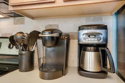 a kitchen counter with a coffee maker and utensils at Seychelles 1601 in Panama City Beach