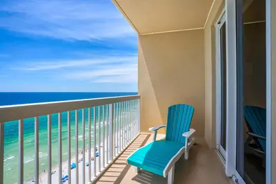 a balcony with a blue chair and the ocean at Seychelles 1601 in Panama City Beach