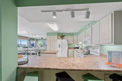 a large kitchen with white cabinets and a large island at The Summit 1512 in Panama City Beach