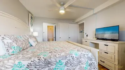 a bedroom with a bed and a flat screen tv at Beachfront - Beach Chairs Included! - FLPCB53 in Panama City Beach