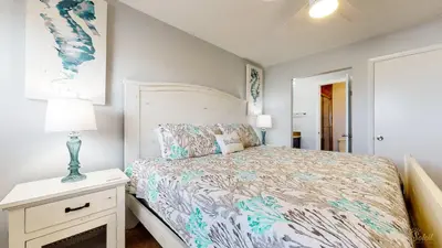 a bedroom with a bed and a lamp on a night stand at Beachfront - Beach Chairs Included! - FLPCB53 in Panama City Beach