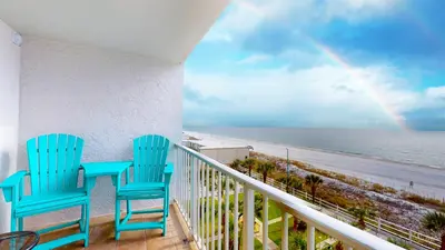 two blue chairs sitting on a balcony with a rainbow at Beachfront - Beach Chairs Included! - FLPCB53 in Panama City Beach
