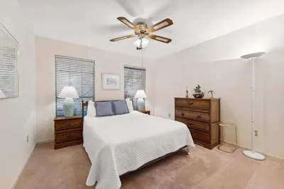 a bedroom with a bed and a ceiling fan at Sandcastle In The Sun in Panama City Beach
