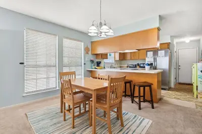 a kitchen and dining room with a table and chairs at Sandcastle In The Sun in Panama City Beach