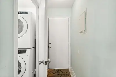 a white laundry room with a washer and dryer at Sandcastle In The Sun in Panama City Beach