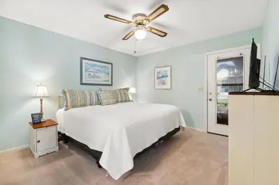 a bedroom with a bed and a ceiling fan at Sandcastle In The Sun in Panama City Beach