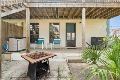 a patio with a table and a grill at Sandcastle In The Sun in Panama City Beach