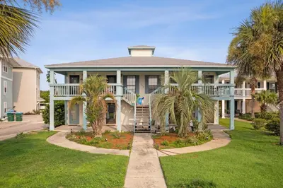 a large house with palm trees in front of it at Sandcastle In The Sun in Panama City Beach