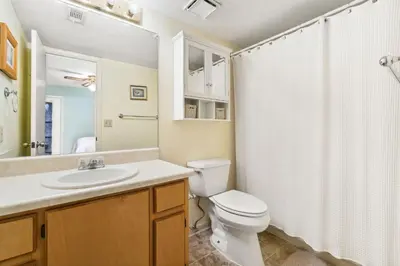 a bathroom with a toilet and a sink and a shower at Sandcastle In The Sun in Panama City Beach