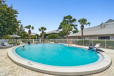a swimming pool with a dolphin in the middle at 30A Beachwood Villas by Panhandle Getaways in Santa Rosa Beach
