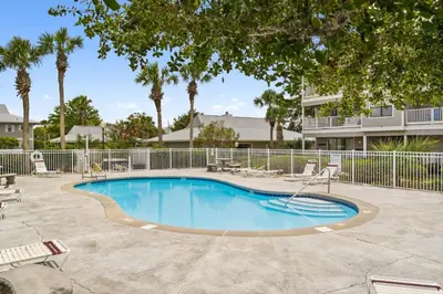 a swimming pool with chairs and a fence at 30A Beachwood Villas by Panhandle Getaways in Santa Rosa Beach