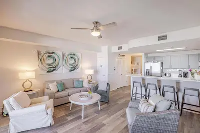 a living room with a couch and a table at Calypso 3-903 - Emerald Getaway in Panama City Beach