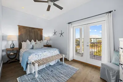 a bedroom with a bed and a sliding glass door at Peaceful Easy Feeling - 156 Chivas Lane, Unit B home in Santa Rosa Beach