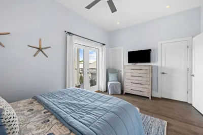 a bedroom with a bed and a flat screen tv at Peaceful Easy Feeling - 156 Chivas Lane, Unit B home in Santa Rosa Beach