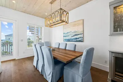 a dining room with a wooden table and blue chairs at Peaceful Easy Feeling - 156 Chivas Lane, Unit B home in Santa Rosa Beach