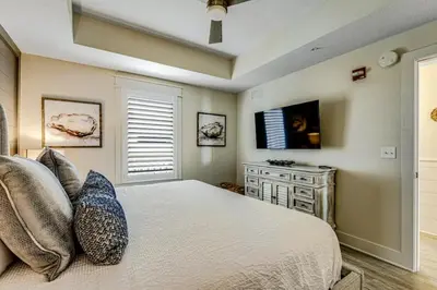 a bedroom with a large bed and a television at Calypso Resort Tower 3 Unit 711 in Panama City Beach