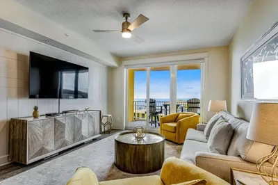 a living room with a tv and a couch and a table at Calypso Resort Tower 3 Unit 711 in Panama City Beach