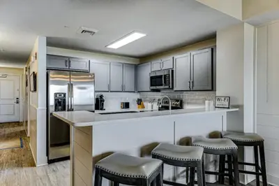 a kitchen with a counter with stools in it at Calypso Resort Tower 3 Unit 711 in Panama City Beach