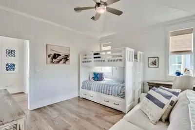 a white bedroom with a bunk bed and a couch at Green Wave in Inlet Beach