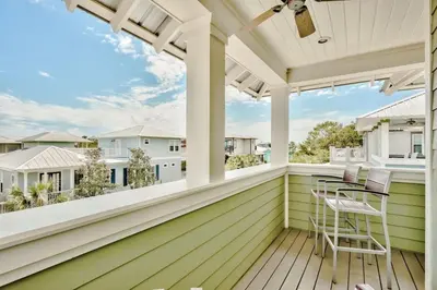 a screened porch with a table and chairs on it at Green Wave in Inlet Beach