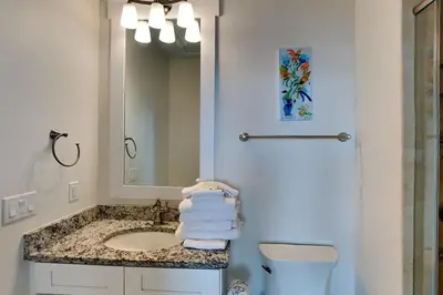 a bathroom with a sink and a toilet and a mirror at Green Wave in Inlet Beach